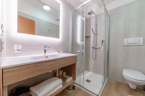 a bathroom with a sink and a shower at Pineta Pastry Hotel in Rocca Pietore