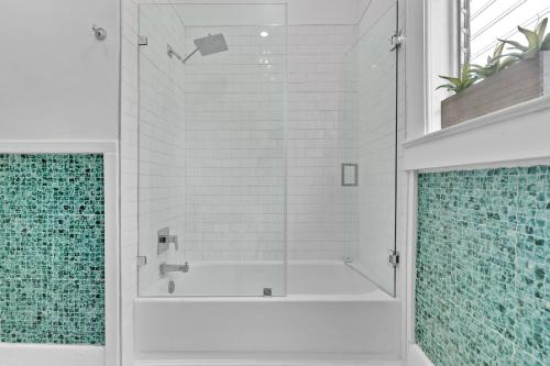 a white bathroom with a shower with blue tiles at Splendid Mediterranean Retreat Gorgeous Outdoor in North Miami