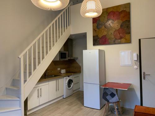 une cuisine avec un réfrigérateur blanc et un escalier dans l'établissement Le Woltu - Appt proche des Halles, à Narbonne