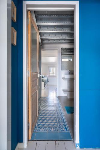 une porte menant à une salle de bain avec un mur bleu dans l'établissement Panorama vue mer et plein centre ville, à La Ciotat