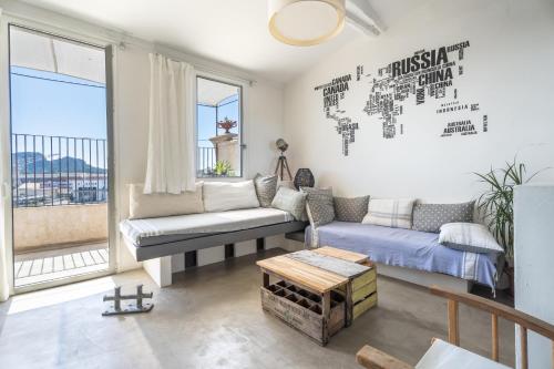 Panorama vue mer et plein centre ville في لاسيوتا: غرفة معيشة مع أريكة وخريطة على الحائط