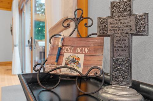 a first book on a bench next to a cross at Mins To Highlands Hot Tub, Fire Pit, Game Room in Franklin