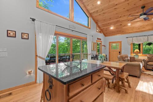a kitchen with a table and a living room at Mins To Highlands Hot Tub, Fire Pit, Game Room in Franklin