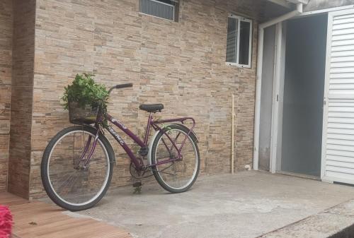 a purple bike parked next to a brick wall at Casa Lagoa Santo Antônio in Laguna