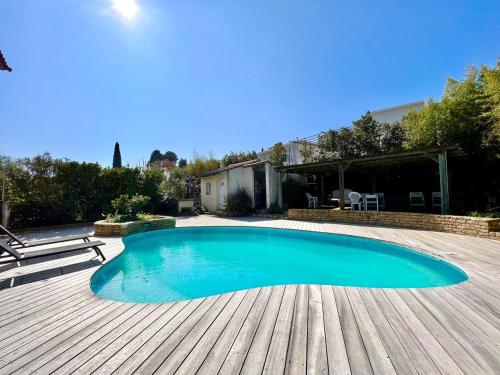 - une piscine sur une terrasse en bois à côté d'une maison dans l'établissement Charming quiet pool villa, à Toulon