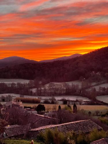 a sunset over a town with mountains in the background at Hotel Cal Sastre in Santa Pau