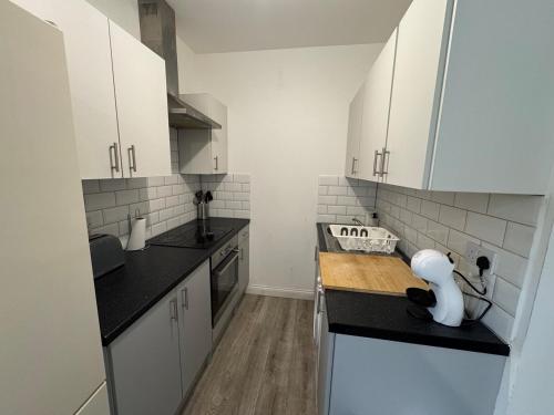 a kitchen with white cabinets and a wooden counter top at 29 Sweet 1 Bed sleeps 4 with free parking BHX NEC in Sheldon