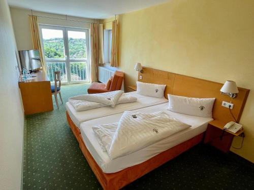 a hotel room with two beds and a window at Berggasthof Hotel Igelwirt in Schnaittach