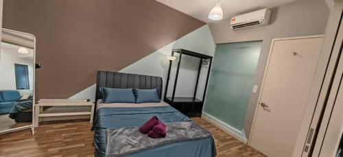 una camera da letto con letto con lenzuola blu e cuscini viola di Sunway Geo Suites BEAB at Sunway City by Ezprop a Subang Jaya
