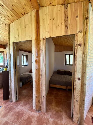 a bedroom with two beds in a room with wooden walls at Associação Quinta das Relvas in Branca