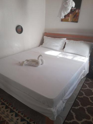 ein weißes Bett, auf dem ein Schwan liegt in der Unterkunft Studio o76,89,76, 73, two in Kisumu