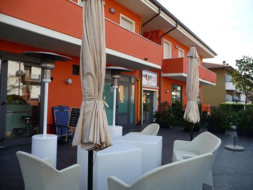 a group of umbrellas and chairs in front of a building at Albergo Borgonovo in Badia