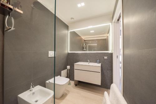 a bathroom with a toilet and a sink and a mirror at Principe del Pardo in Catania