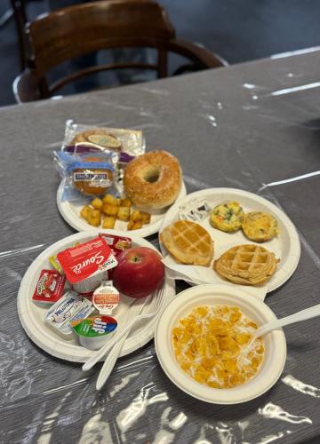 a table with plates of breakfast food on it at Zero - 100 Motor Inn in Heron Bay