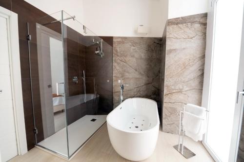 a bathroom with a white tub and a shower at Principe del Pardo in Catania