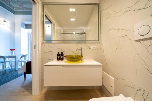 a white bathroom with a sink and a mirror at Principe del Pardo in Catania