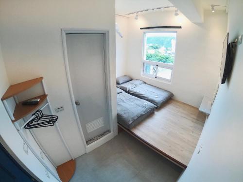 a small room with a bed and a window at Go On Vacation Hostel Green Island in Green Island