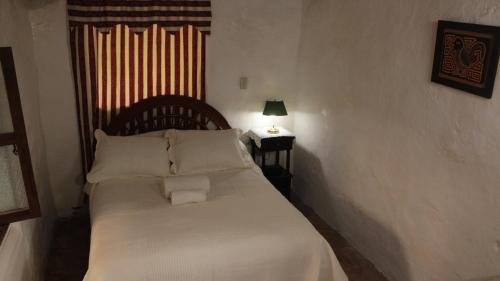 Un dormitorio con una cama blanca con dos almohadas. en La Posada de Juancho, en Junín