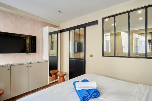 - une chambre avec un lit et des serviettes bleues dans l'établissement Rent a Room - Studio Bonne Nouvelle, à Paris