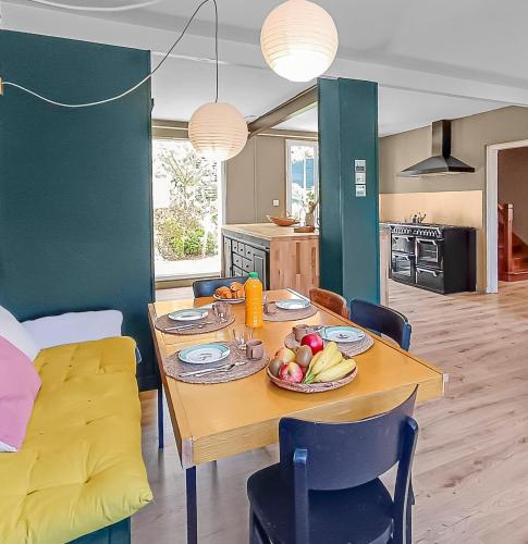 - une table à manger avec une assiette de fruits dans l'établissement Maison plages & centre à pieds - proche GR34, à Saint-Pol-de-Léon