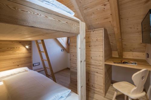 a bedroom with a bunk bed and a desk at Osti Nicl in San Martino in Badia