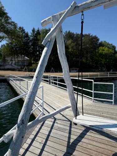 a wooden dock with a swing on a boat at Domek nad jeziorem Łagów - Mundi, Lake Park in Łagów