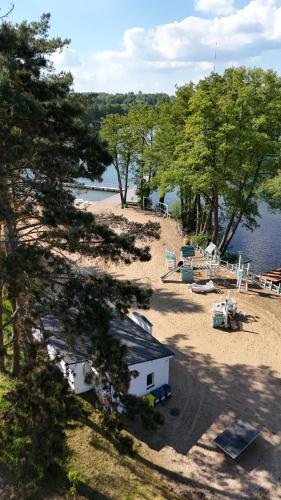 a house on a beach next to a body of water at Domek nad jeziorem Łagów - Mundi, Lake Park in Łagów