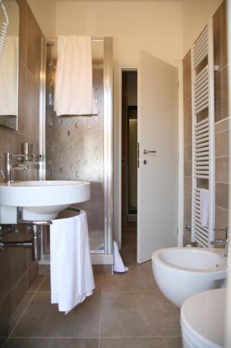 a bathroom with two sinks and a toilet and a shower at Albergo Borgonovo in Badia
