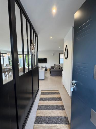 un couloir avec une porte bleue et un salon dans l'établissement L'Olivier de munet, à Distré