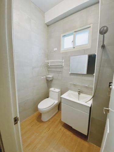 a bathroom with a toilet and a sink and a window at Go On Vacation Hostel Green Island in Green Island