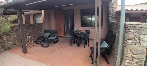 スティンティーノにあるCasa Stintino, vicino spiaggia La Pelosaの石壁のパティオ(テーブル、椅子付)