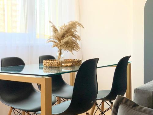 a dining room with a glass table and black chairs at PROMO Elegant Apartments NEW - Colorful by the sea in Durrës