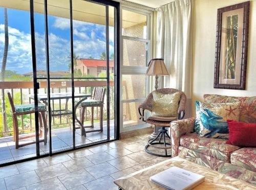 een woonkamer met een bank en een balkon met een tafel bij Maui Vista 3213 condo in Kihei