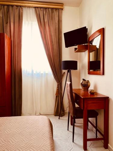 a bedroom with a desk and a bed and a window at Bella Vista in Balíon