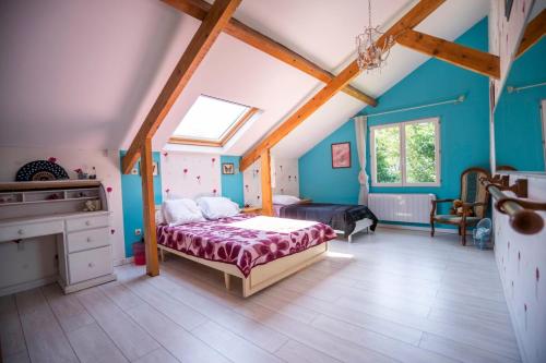 une chambre avec un lit dans une pièce aux murs bleus dans l'établissement Chalet de Cornalis, à Morcenx