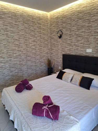 a bedroom with a bed with purple towels on it at EFReMIAS PLACE in Rhodes Town