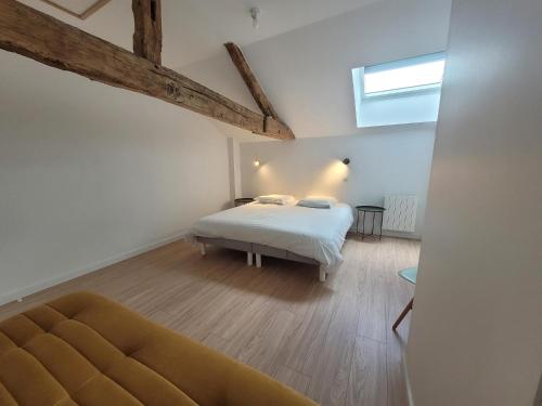 a bedroom with a bed and a couch in a room at Le Gîte 4 étoiles à la campagne adapté "PMR" in Antran