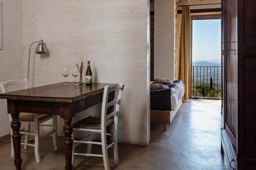 a dining room with a table and two glasses of wine at VALDONICA WINERY Fine Dine & Wine Hotel in Sassofortino