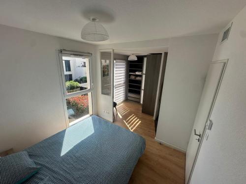 une chambre avec un lit bleu et une fenêtre dans l'établissement Maison indépendante avec jardin dans résidence proche de la plage, à Sérignan