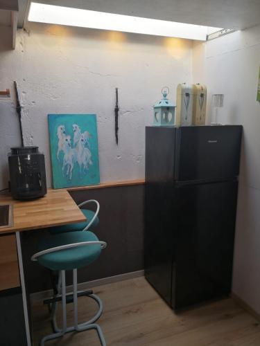 an office with a desk and a chair and a refrigerator at WitteZwaan in Harlingen