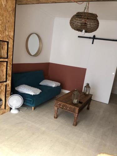 un salon avec un canapé bleu et une table dans l'établissement Cœur, à Palavas-les-Flots
