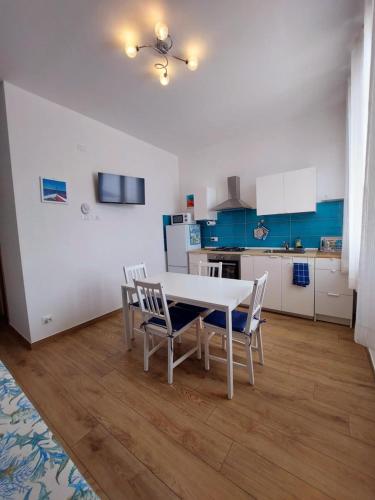 a kitchen with a table and chairs in a room at Blue Sicily Apartment in Roccalumera