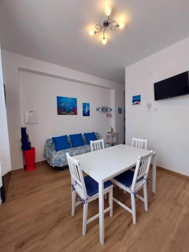 a room with a white table and chairs and a bed at Blue Sicily Apartment in Roccalumera