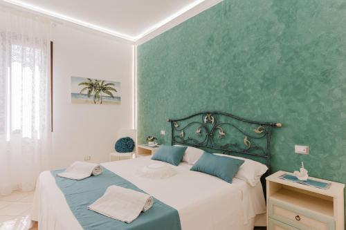 una camera da letto con due letti e una parete verde di B&B Le Ortensie a San Vito lo Capo