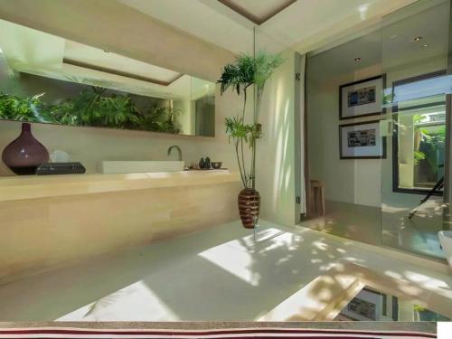 a bathroom with a counter with plants on the wall at Kawung Villa Canggu in Canggu