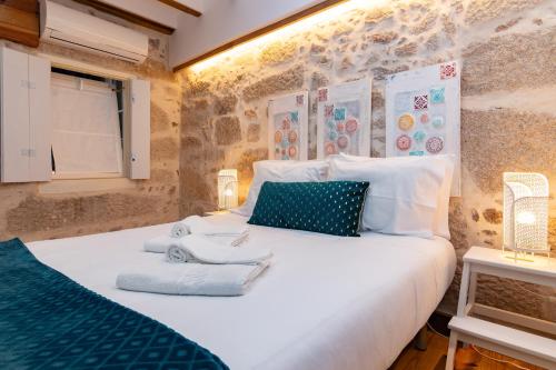 a bedroom with a white bed with towels on it at Douro View House Ribeira in Porto