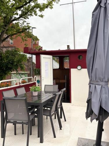 a table and chairs and an umbrella on a patio at Gîte Le Sambre in Thuin