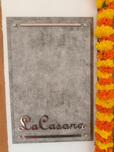 a sign for a restaurant with flowers around it at La casona in Kottayam