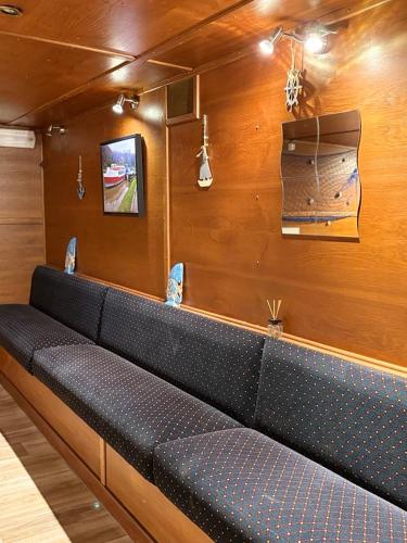 a black couch in a room with wooden walls at Gîte Le Sambre in Thuin