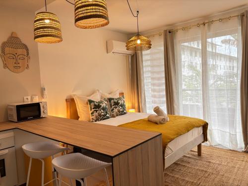 a bedroom with a bed and a desk with chairs at Bali à la ZAC Hibiscus - Terrasse in Cayenne